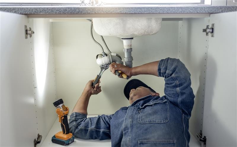 Plumber repairing kitchen sink drain pipes in Union City, Georgia