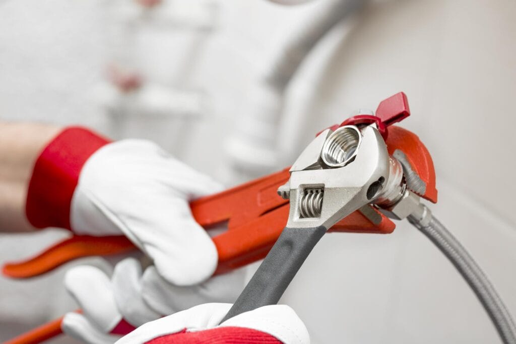 Plumber holding pipe wrenches for an emergency repair in Union City