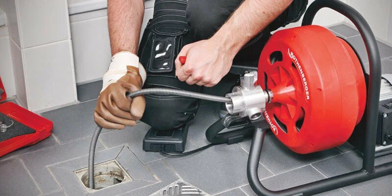 Plumber using a drain-cleaning machine in Union City