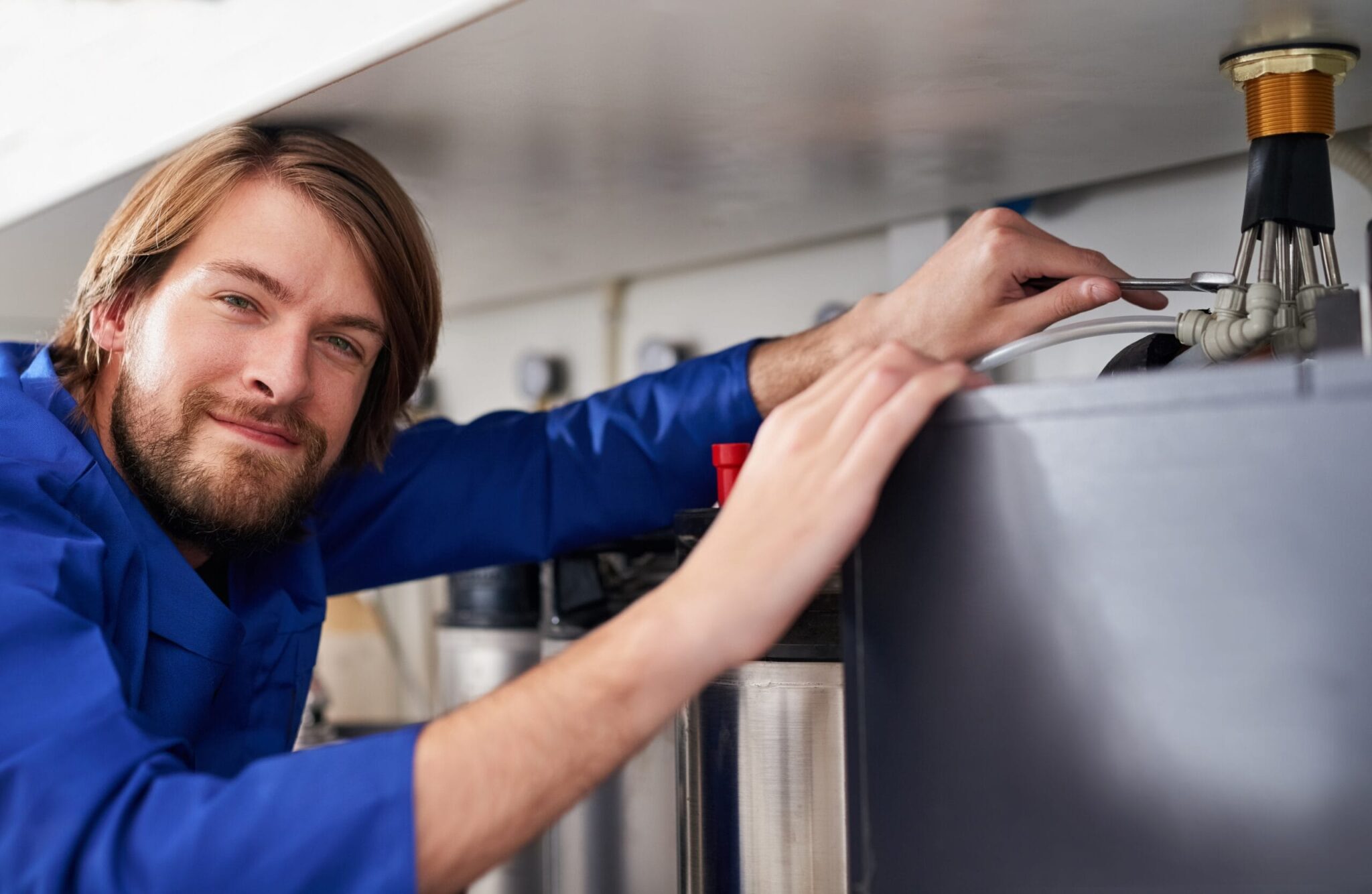 Technician servicing a residential water heater tank in Union City